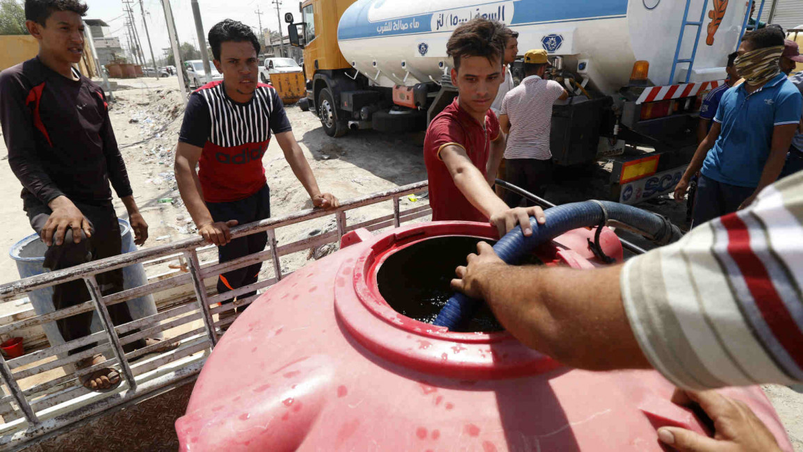 Iraqi youth fill up a water tank in Basra