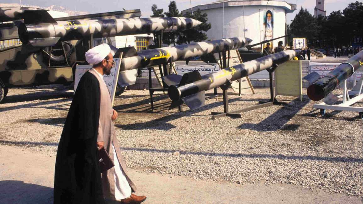 Iran clergyman walks past missile display