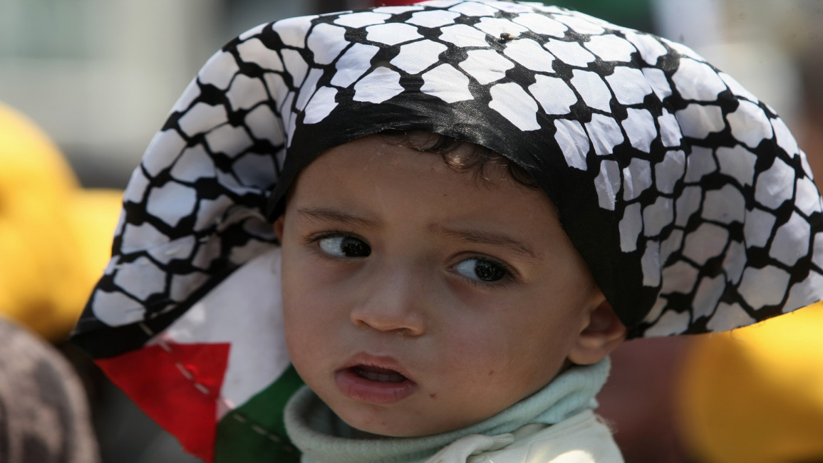 طفل فلسطيني يعتمر الكوفية الفلسطينية