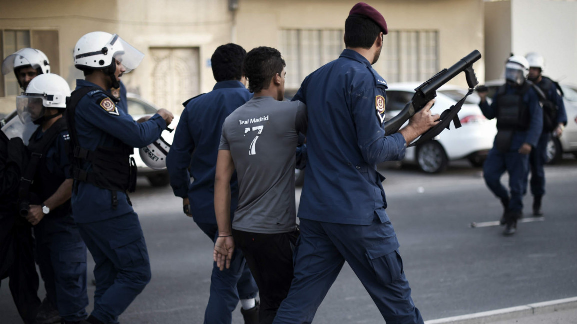 Bahraini police arrest a Shia protester