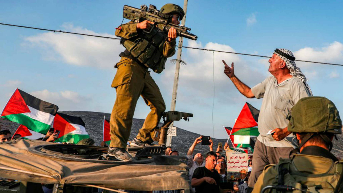 Israeli soldier and Palestinian man - AFP
