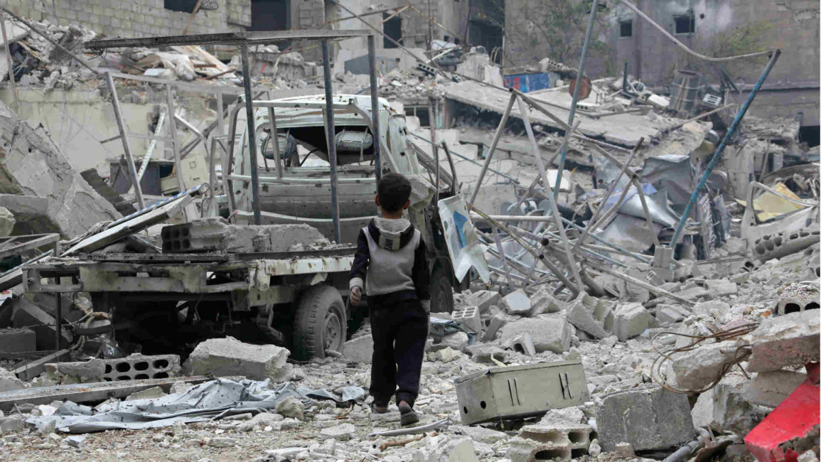 Syrian boy walks past rubble in Eastern Ghouta