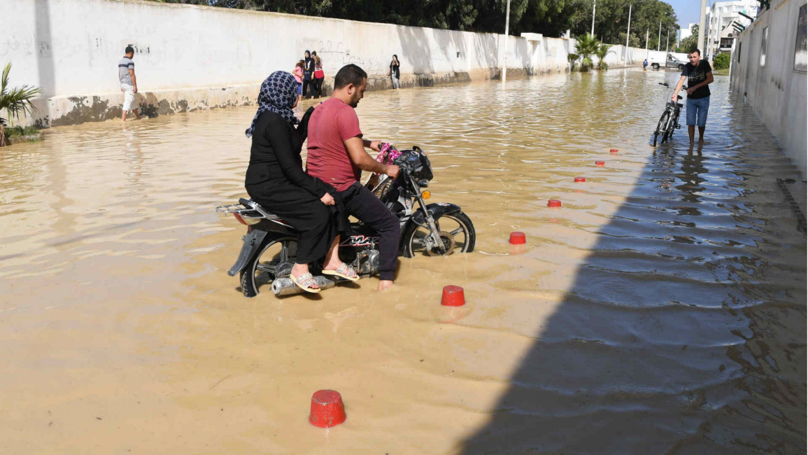 Motorcyclist rides in flooded street