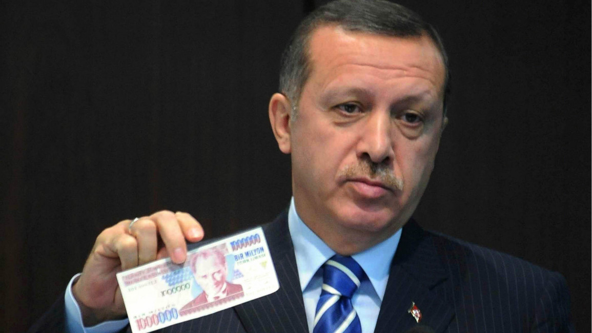 Erdogan holding old Turkish lira banknote