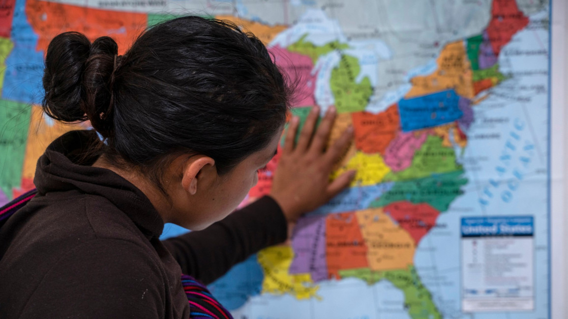 Guatemalan woman touches map at refugee centre. [Getty]
