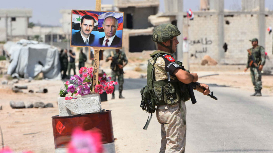 Assad Putin posters Idlib - AFP