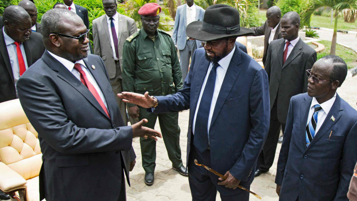 Riek Machar shakes hands with President Salva Kiir