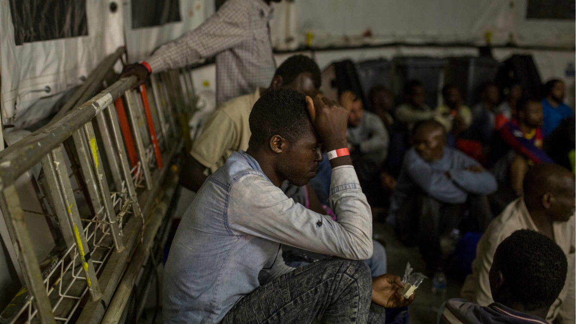 A migrant rests on the deck of rescue ship