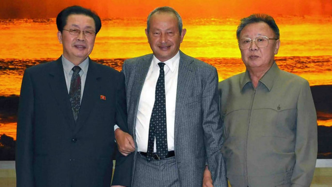 Naguib Sawiris stands hand in hand with late North Korean Supreme Leader Kim Jong-Un and Kim Yong-nam [NCNA]